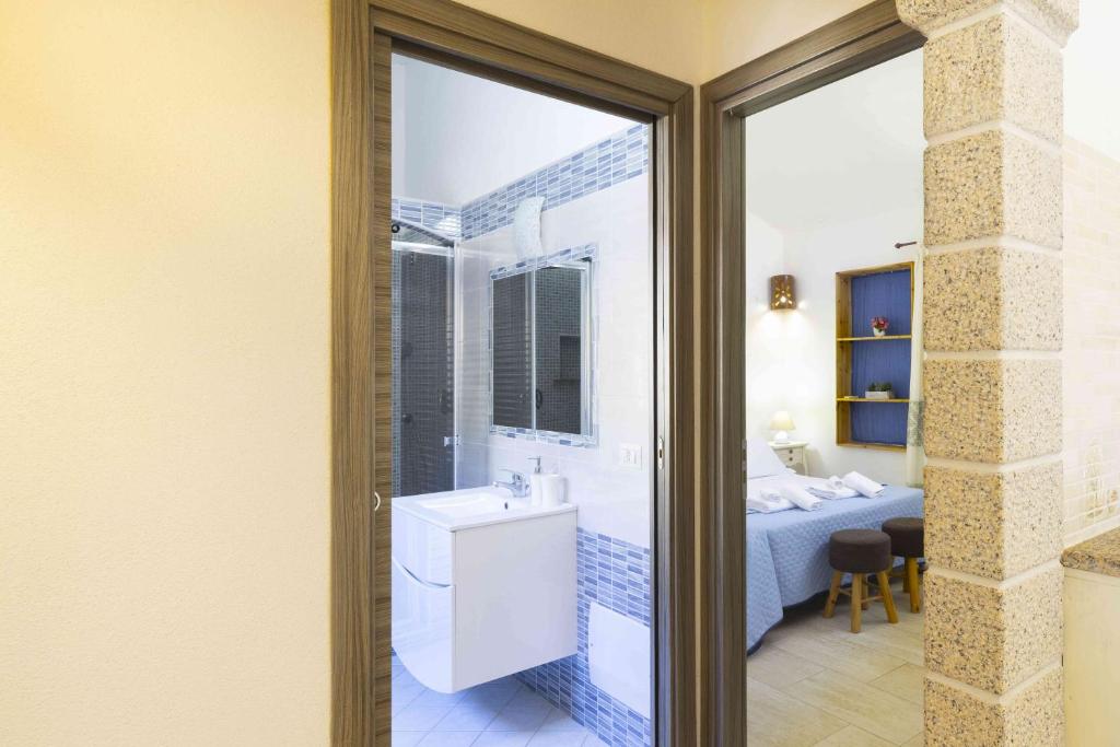 a bathroom with a tub and a sink and a bedroom at Panoramic Seaview Coastal Retreat with Pool in Cugnana