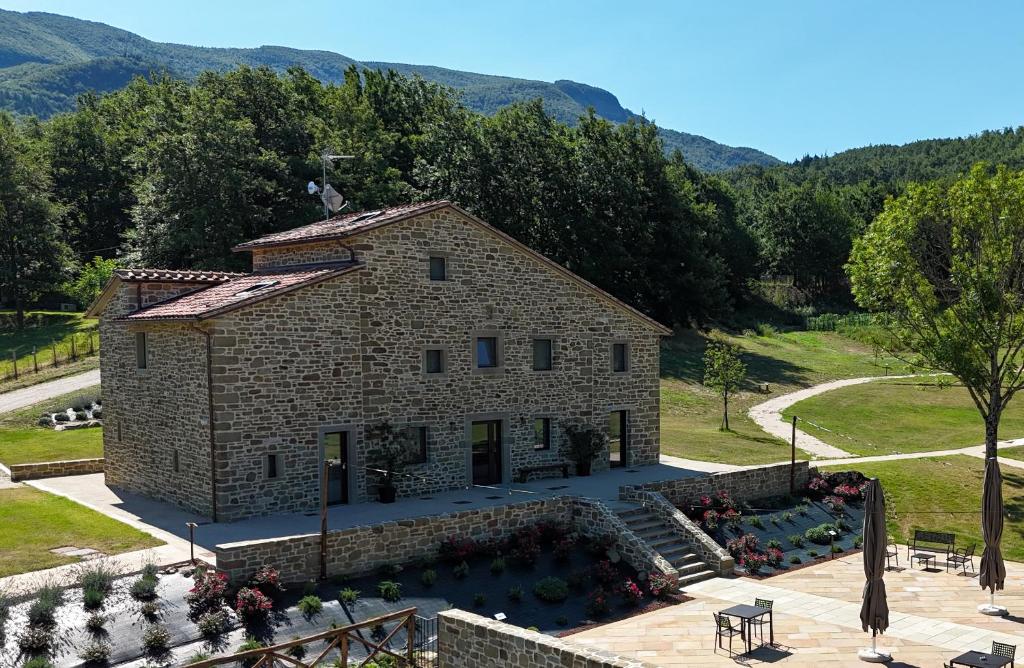an external view of a stone house with mountains in the background at Agriturismo Bramalpane in Bagno di Romagna