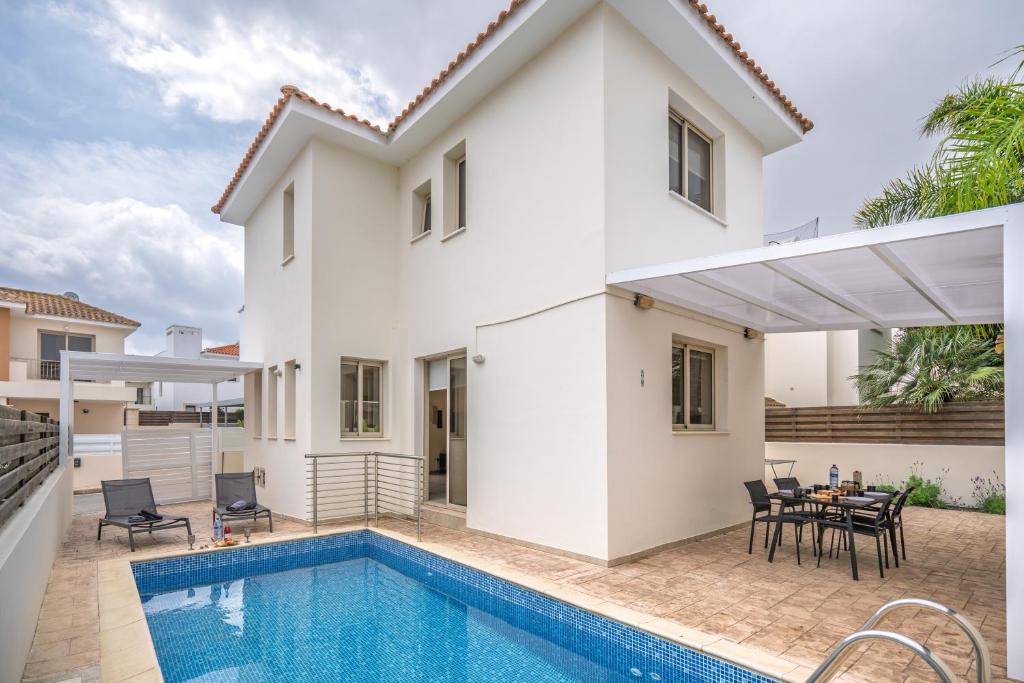 a villa with a swimming pool and a house at Mambo Private Villa with Pool by the Beach in Paralimni