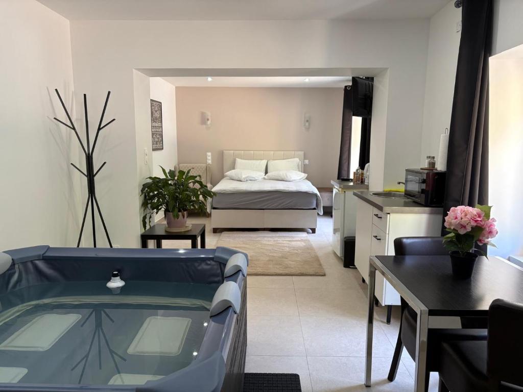 a room with a bath tub and a bedroom at Hôtel-Restaurant Belle'man in Longevelle-sur-Doubs