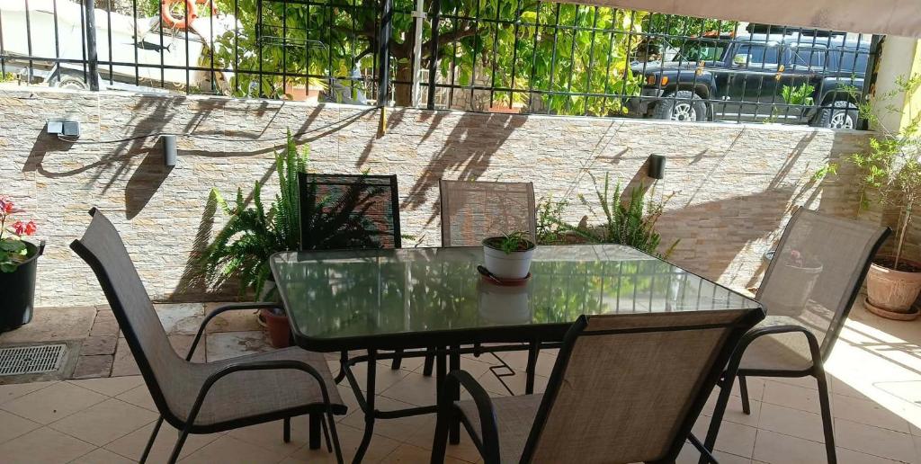 a glass table and chairs on a patio at Liliana's house in Kallithea Halkidikis