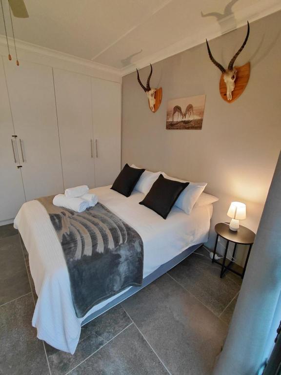 a bedroom with a bed with antlers on the wall at GOOSE Nest in Gonubie