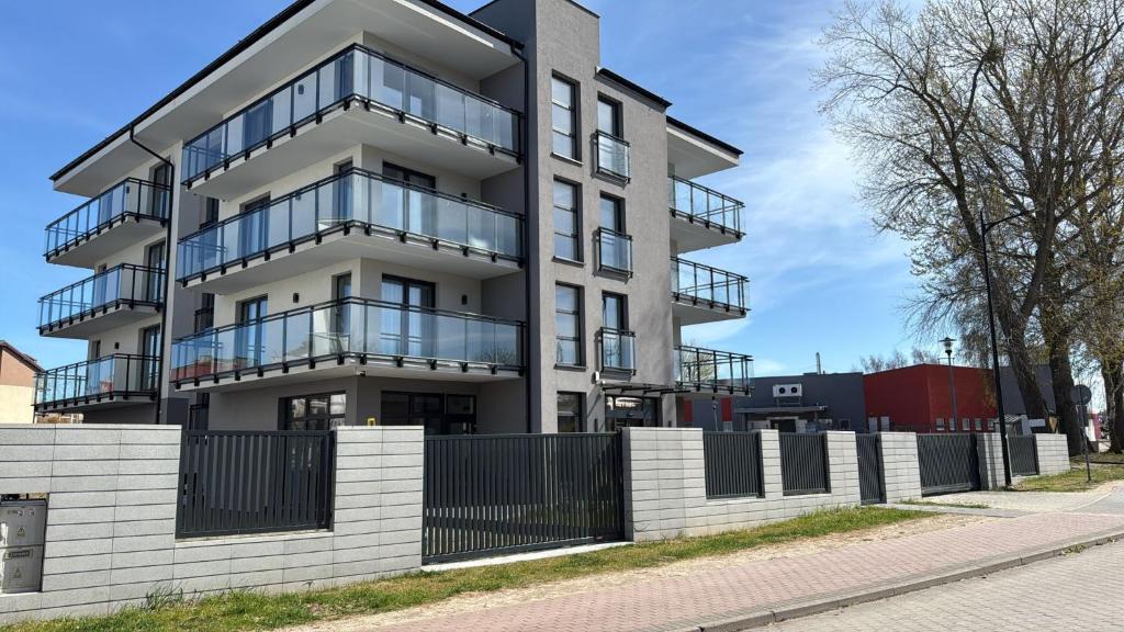 an apartment building with a fence in front of it at Baltic Stay in Władysławowo