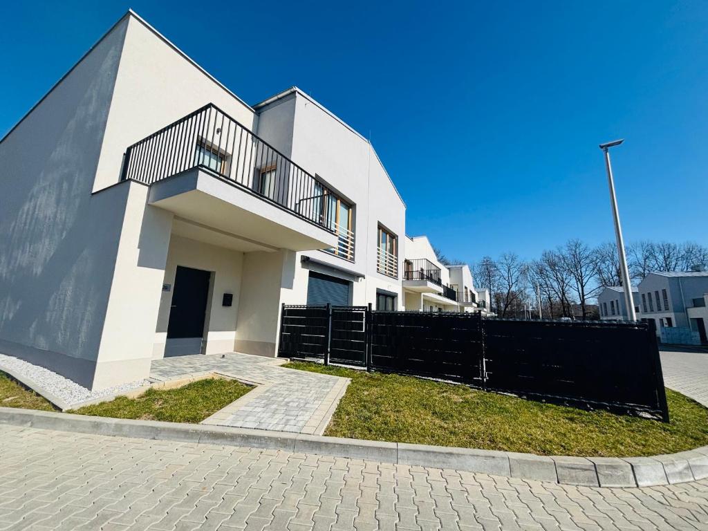 a white house with a black fence in front of it at Słoneczny Taras in Kęty