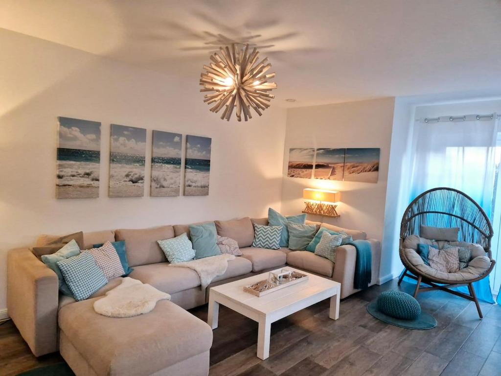 a living room with a couch and a table at Ferienhaus Oberhüs - Das Familien-Ferienhaus an der Ostsee in Scharbeutz