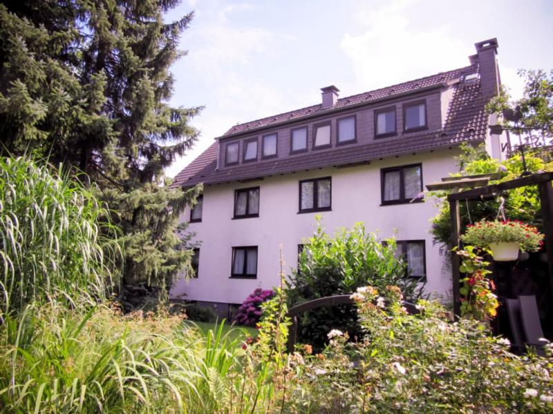 een groot wit huis met veel planten bij Hotel Zur Flora in Essen