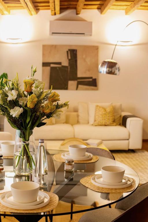 a living room with a table with a vase of flowers at Como Icon Centro Apartment By Icon7 Luxury in Como