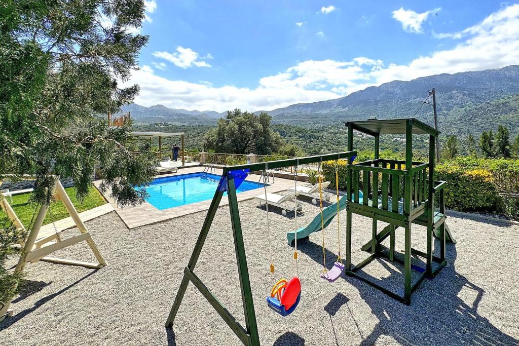 a playground with a pool and a swing at Villa Gianna by PosarelliVillas in Fílippos