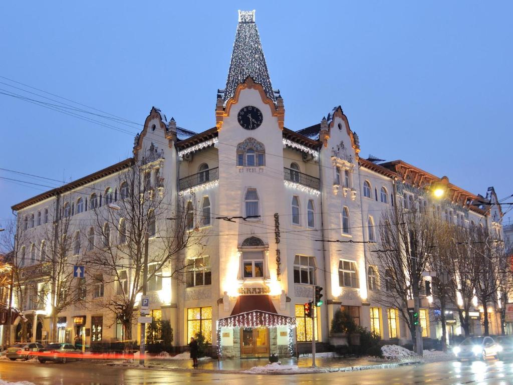 ein großes weißes Gebäude mit einem Uhrturm darauf in der Unterkunft Grand Hotel Ukraine in Dnipro