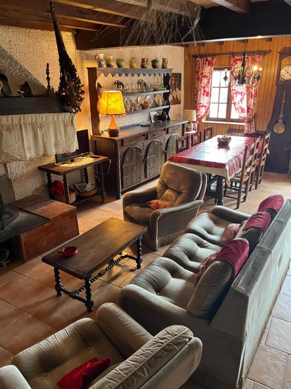 a living room with couches and a table and a fireplace at La Régalade, Pyrénées in Sorgeat