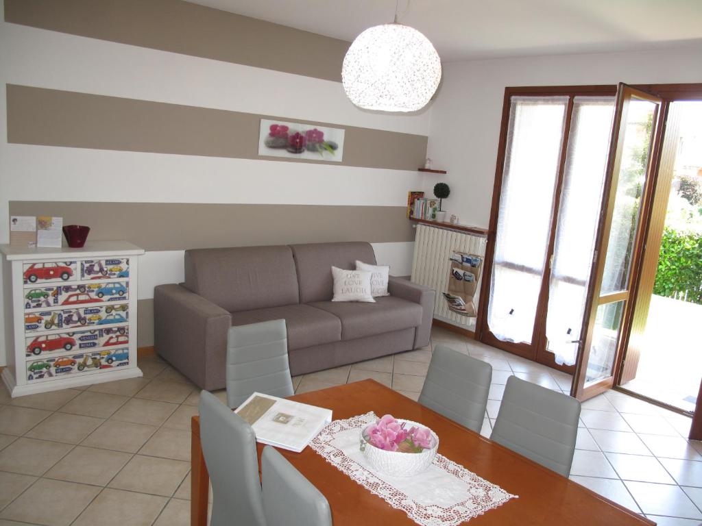 ein Wohnzimmer mit einem Tisch und einem Sofa in der Unterkunft In vacanza da Miki 01 in Desenzano del Garda