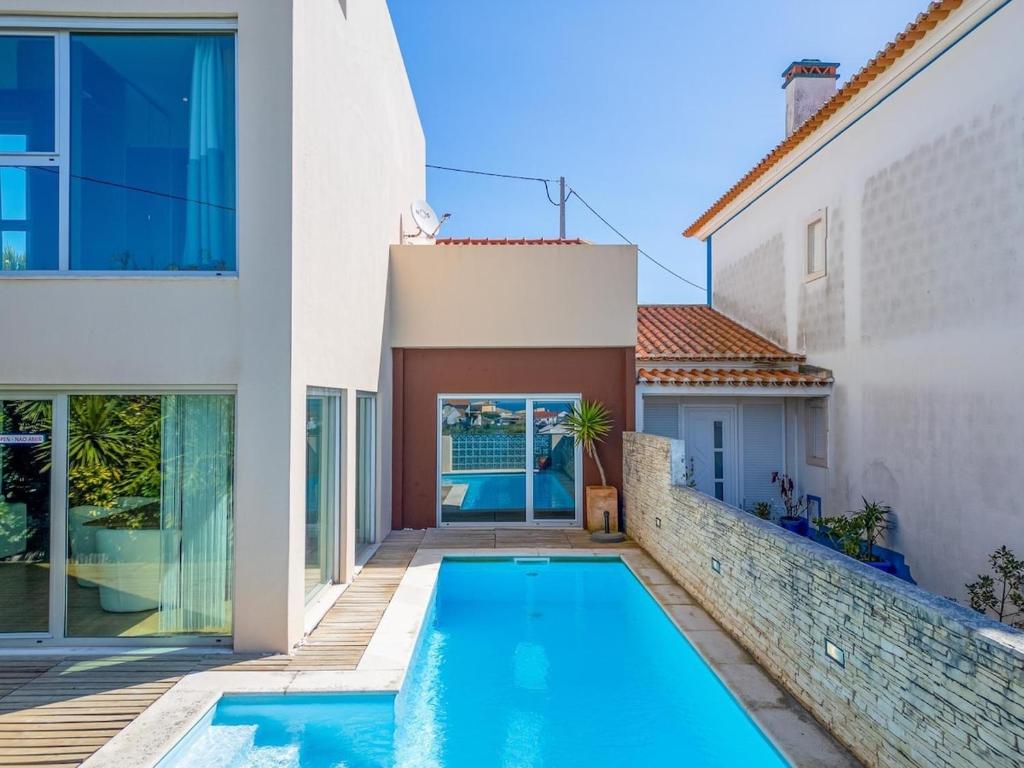 a swimming pool in the backyard of a house at Torres Vedras House in Silveira