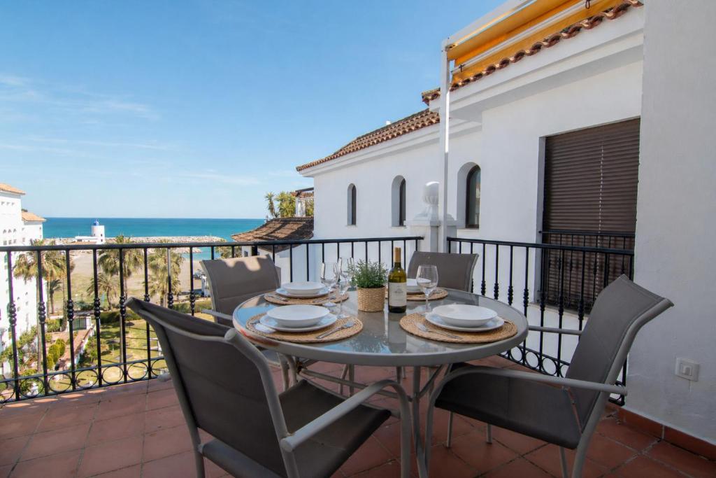 a table and chairs on a balcony with the ocean at 2233-Lovely 2 bedrooms on the beach, pool and port in Manilva