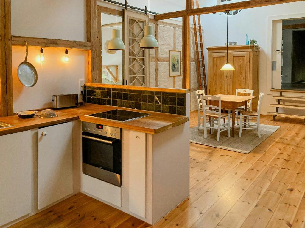 a kitchen with a stove top oven next to a table at Apartment In A Converted 1875 Creamery in Travenhorst