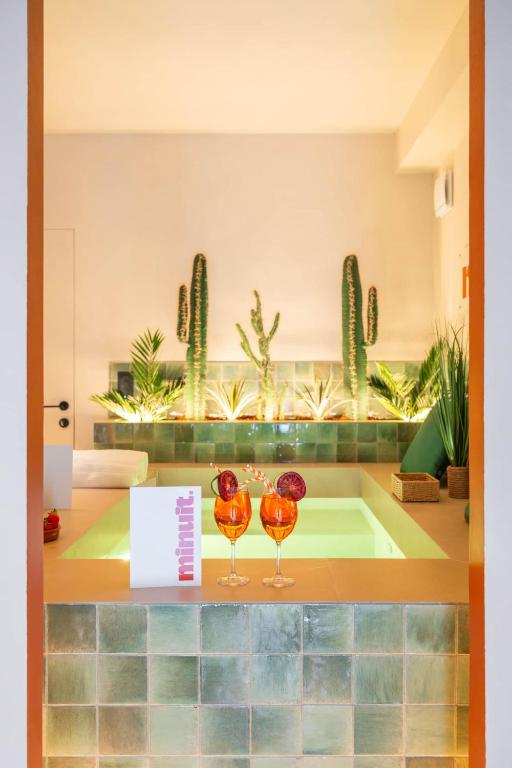 Zwei Weingläser stehen auf einer Theke. in der Unterkunft minuit - Love Room avec jacuzzi privatif et hammam Marseille Aix in Vitrolles