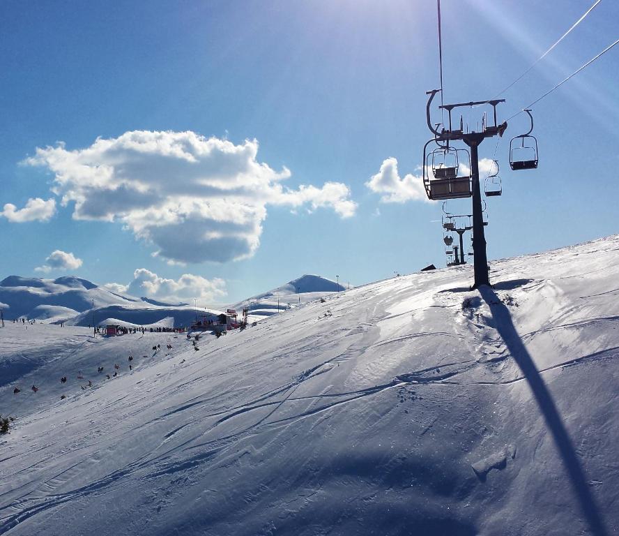 a ski lift on top of a snow covered slope at Hotel Fersped in Mavrovo