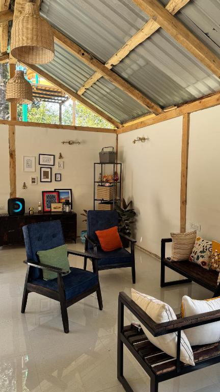 a living room with chairs and a ceiling with beams at SAANJH, Shangarh in Shangarh