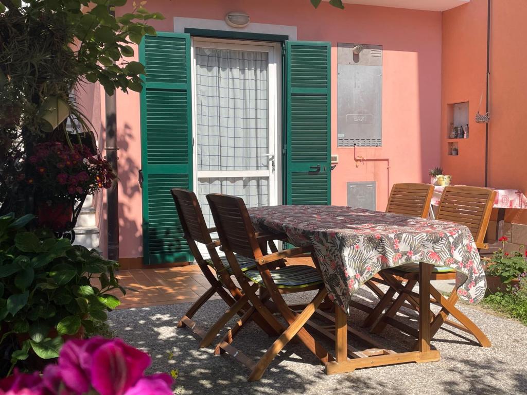 a table and chairs in front of a green door at Casa Mare Blu codice CITRA OO9O34 LT 1168 in Loano