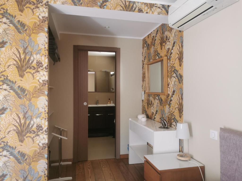 a hallway with a bathroom with a sink and a mirror at U Muzzelo in Oletta