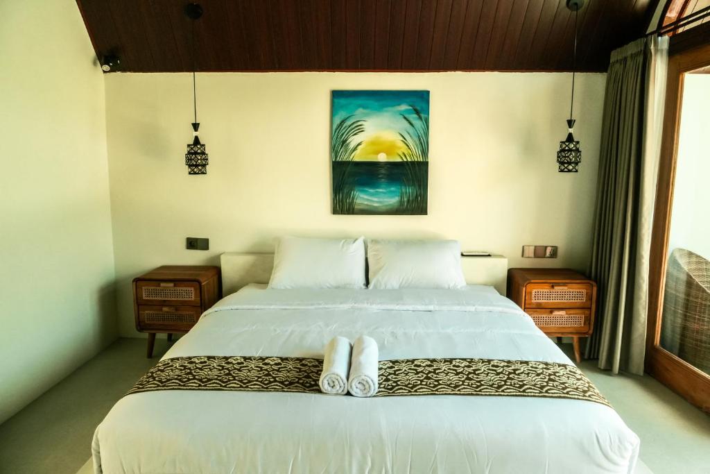 a bedroom with a bed with two towels on it at Asem Bungalows in Kuta Lombok