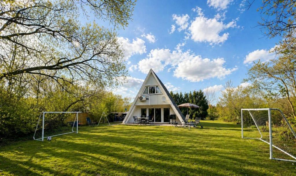 a house with a triangular roof with soccer nets in the yard at Dachzelt Oase Damp in Damp
