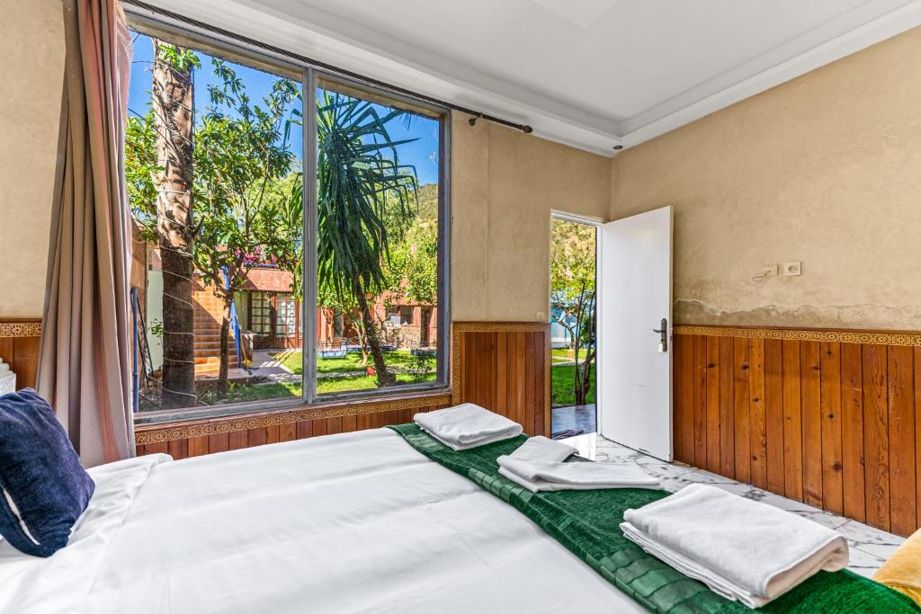 a bedroom with two beds and a large window at Riad Rêve D'Ourika in Ourika