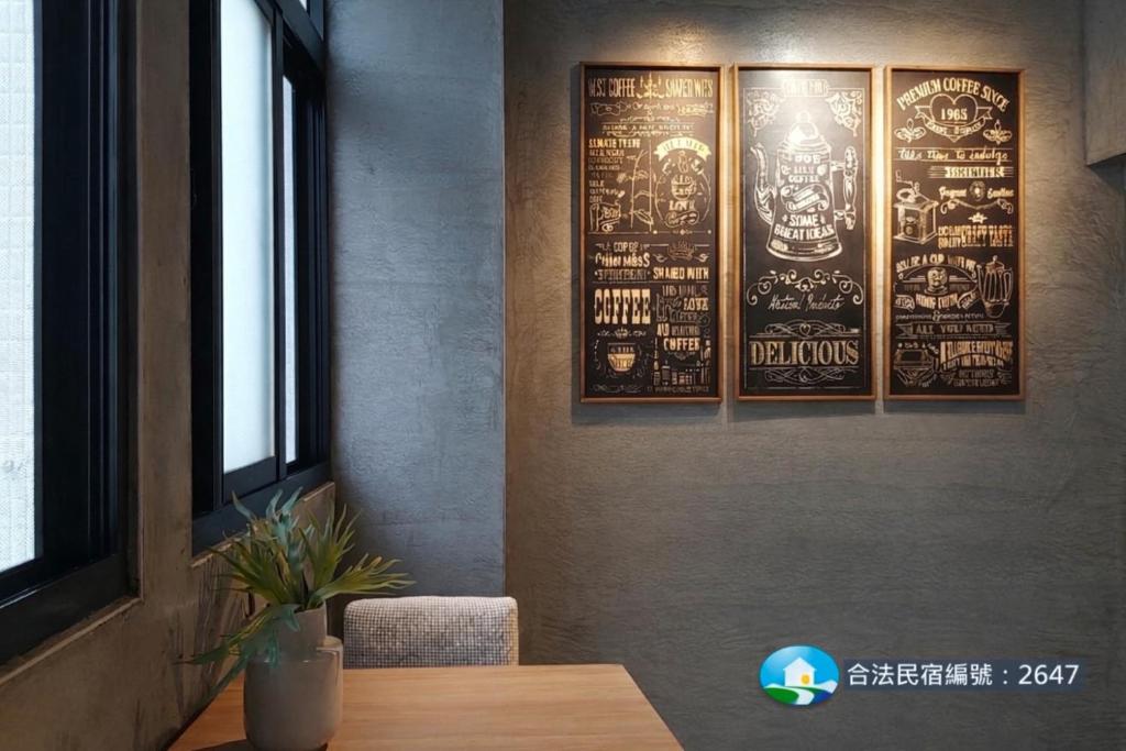 a dining room with a table and posters on the wall at Huck B&B in Hualien City