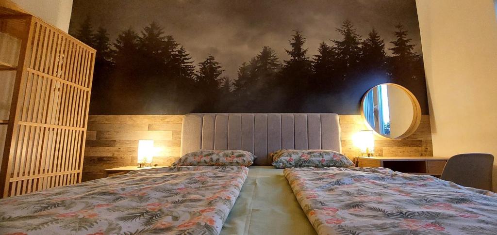 a bedroom with a bed with a large painting on the wall at My Life 20 - Green Hill in Soko Banja