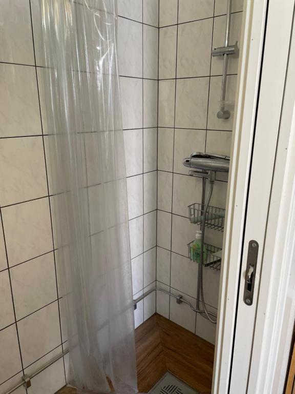 eine Dusche mit Duschvorhang im Badezimmer in der Unterkunft Martens studio in Malmö
