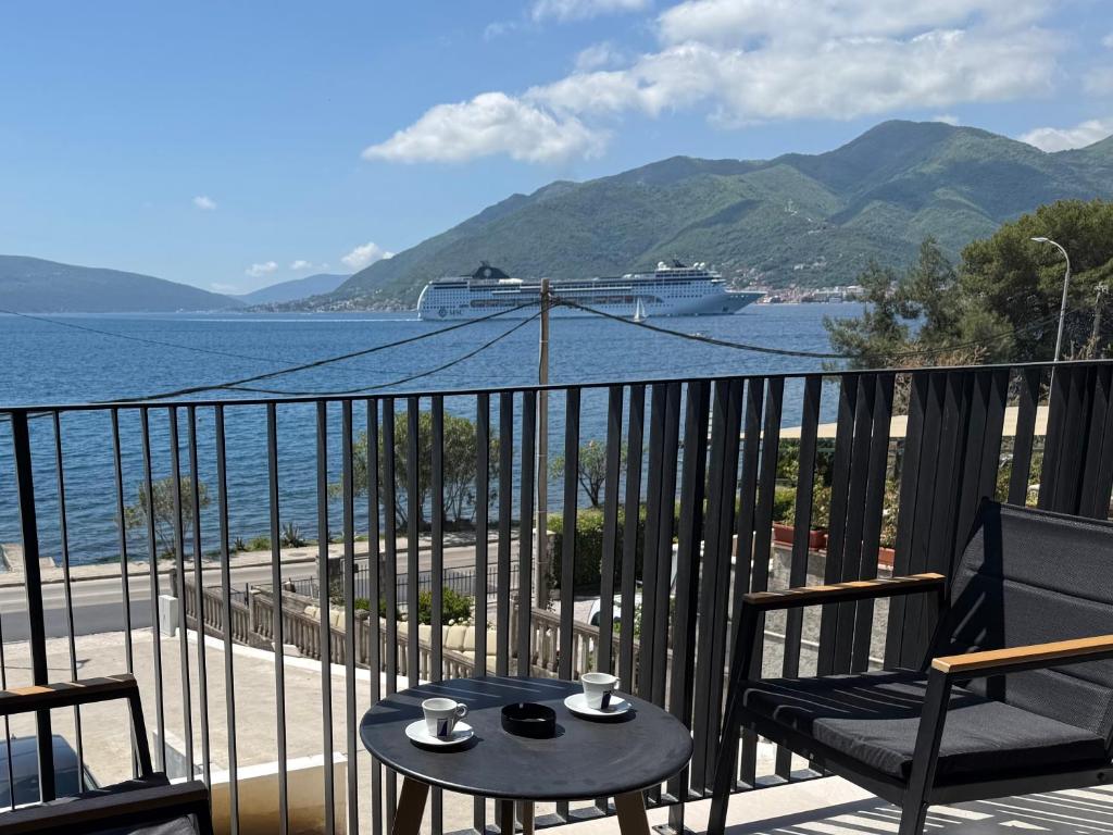 a balcony with a view of the ocean and a cruise ship at Seafront apartment Tivat in Donja Lastva