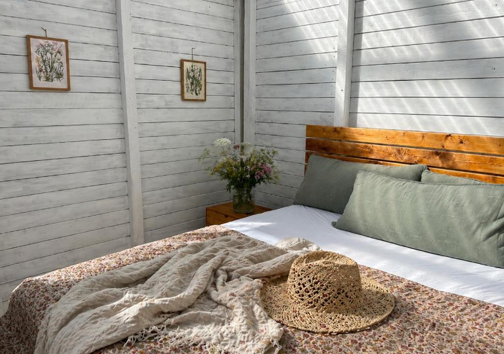 ein Schlafzimmer mit einem Bett, auf dem ein Hut liegt in der Unterkunft SleepOrup in Faxe