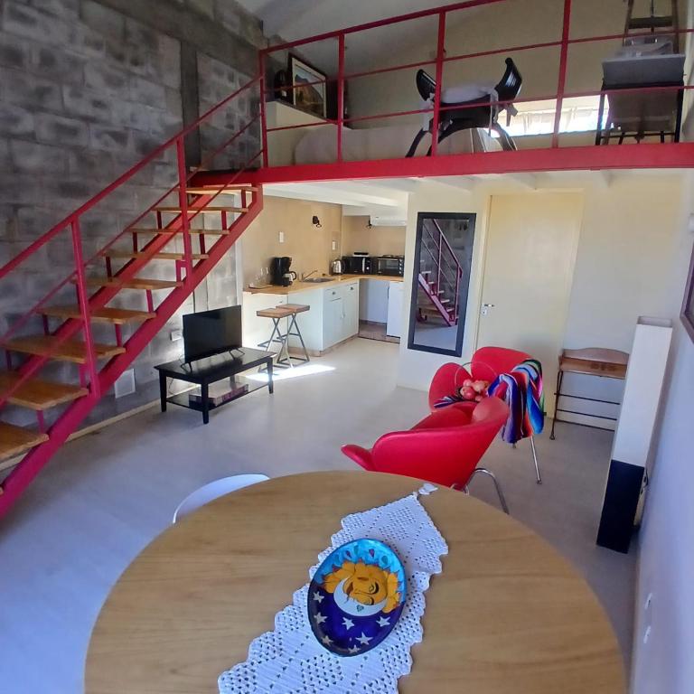 ein Wohnzimmer mit Tisch und Galerie in der Unterkunft PATO BLANCO in Ciudad Lujan de Cuyo