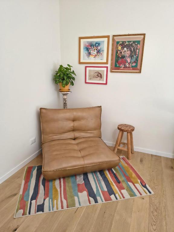 a brown leather couch sitting on a rug in a room at B&B La stanza del sole in Modena