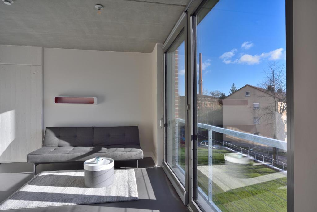 - un salon avec un canapé et une grande fenêtre dans l'établissement Loft Apartments, à Schorndorf