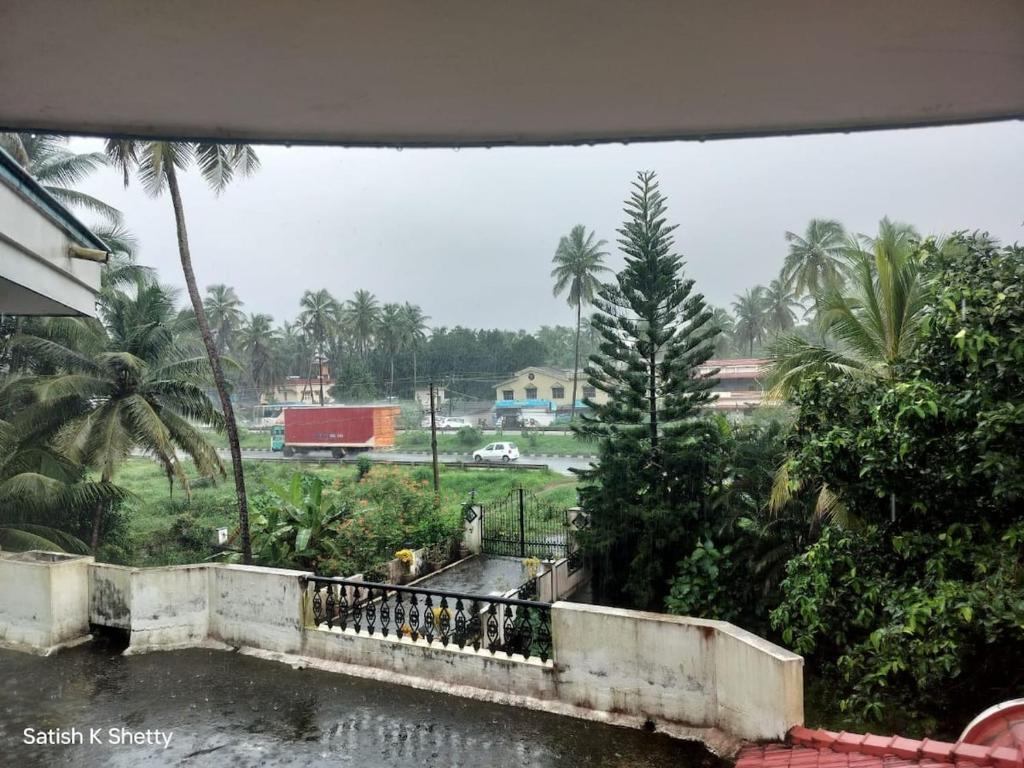a view of a river with palm trees and a field at Rajmata Nivas in Kaup