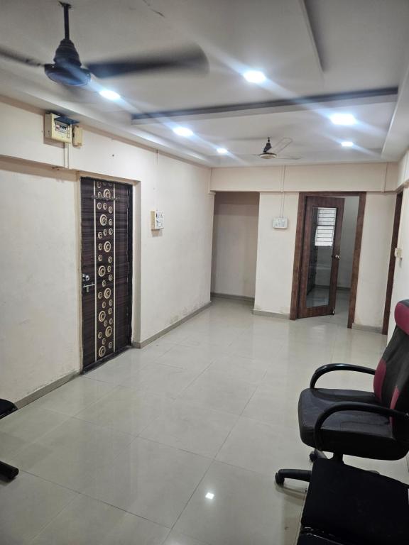 an empty room with chairs and a door at Homenest Stay in Nashik