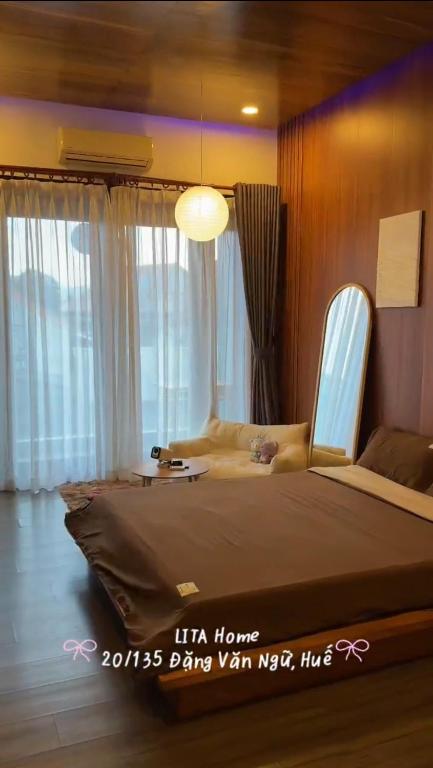 a large bed in a room with windows at Lita Homestay in Thôn Trường Giang