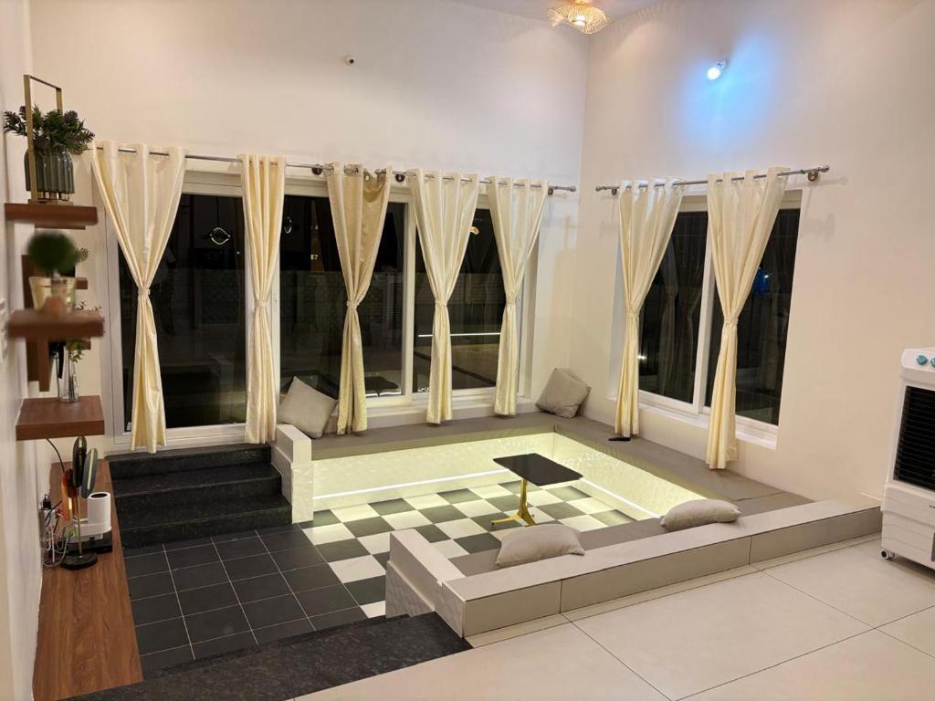 a living room with a couch and some windows at Sunset Villa in Mysore