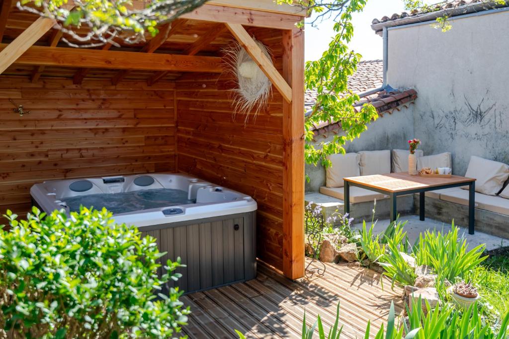 a hot tub in a backyard with a pergola at Escale victorienne in Saint-Étienne