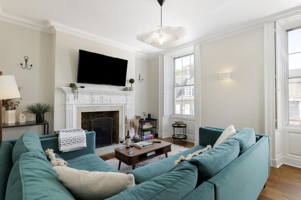 a living room with a blue couch and a fireplace at Molls Yard in Chipping Norton