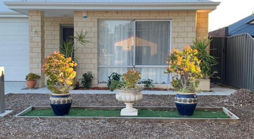 three vases with flowers in them in front of a house at Deluxe Queen Room in Perth