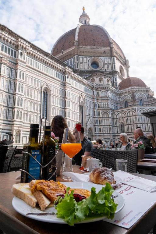 a plate of food on a table in front of a building at Rjgal Apartment B&B - Private Courtyard Florence Center in Florence