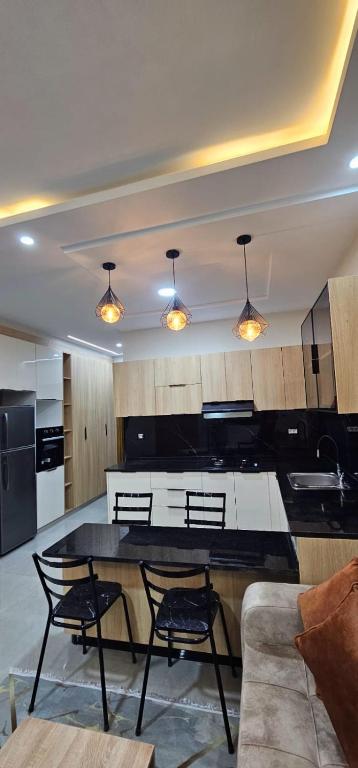 a kitchen with a table and chairs in a room at Maison salakta in Ksour Essaf