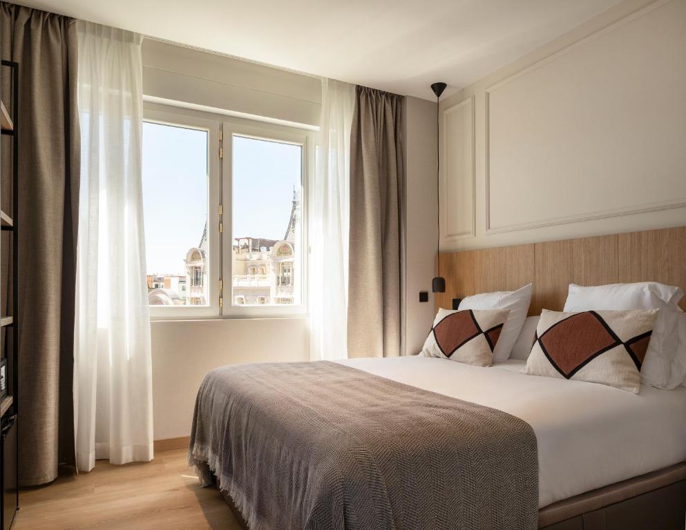 a bedroom with a large bed and a window at Feelathome Cortes in Madrid