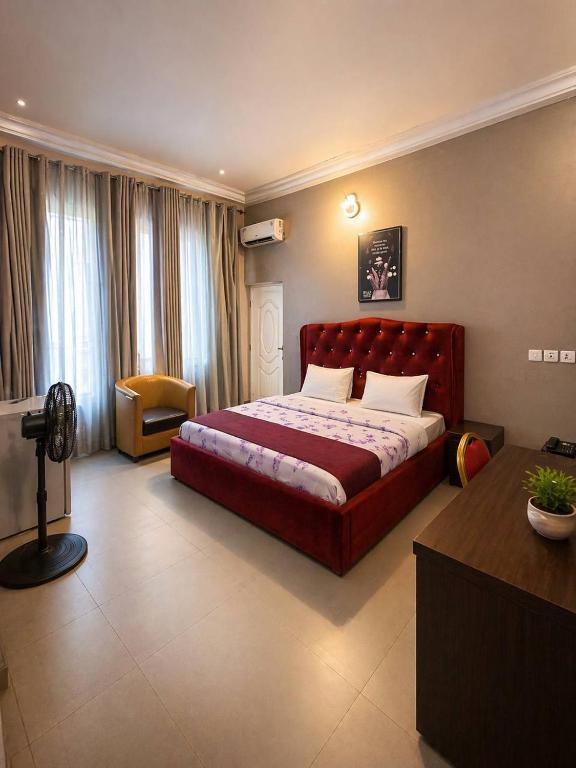 a bedroom with a large red bed in a room at MBL Hotel and Resort in Alakohia