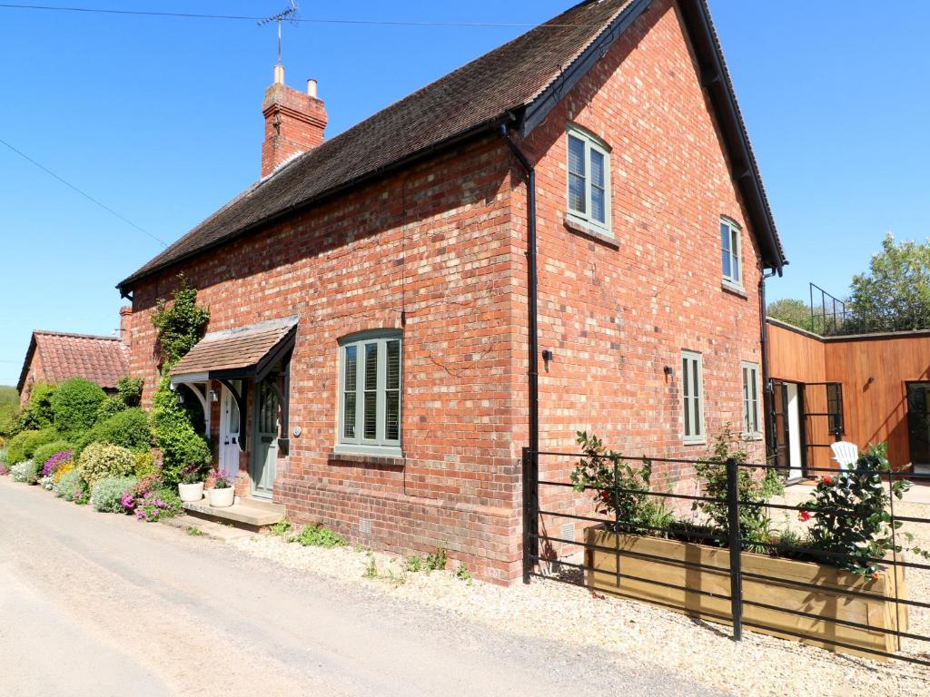 a red brick building with a gate on a street at Gardeners Cottage in Oakham