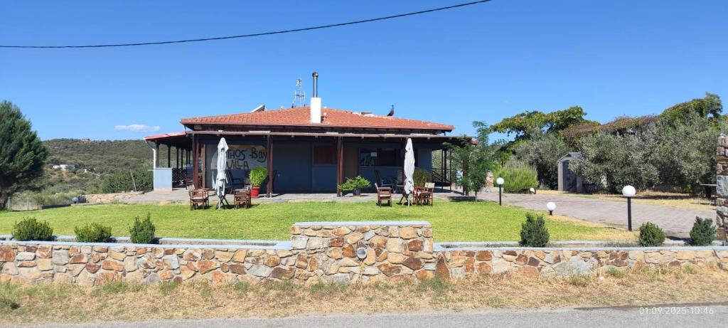a building with a stone wall in front of it at Athos Bay Villa in Ammouliani