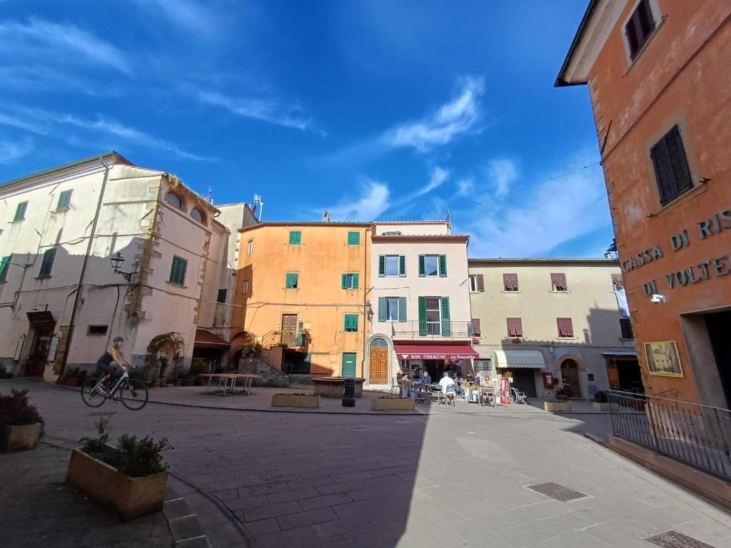 a group of buildings on a street with a person riding a bike at Appartamenti - AL4 in Guardistallo
