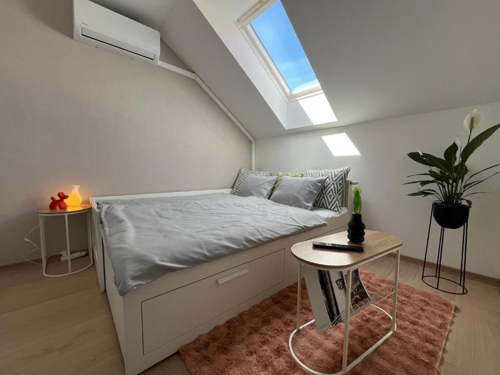 a small bedroom with a bed with a skylight at Main Square Olive Studio in Trnava