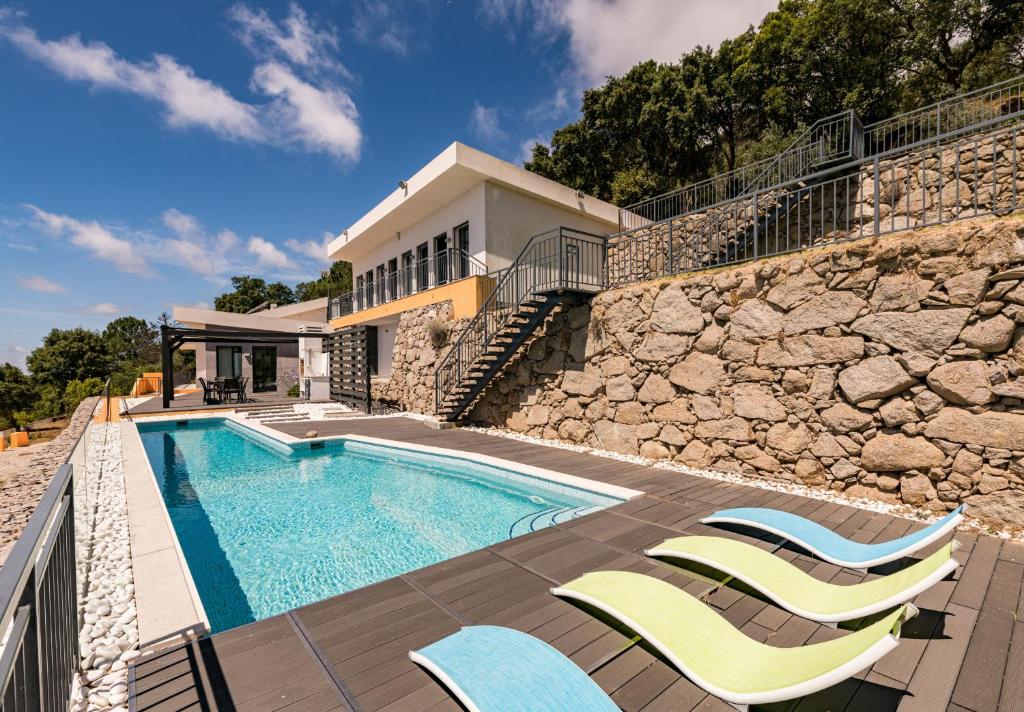 a villa with a swimming pool and a stone wall at Villa Monchique in Monchique